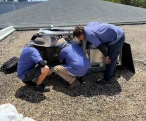 Two Value Air and Heat technicians servicing a rooftop HVAC unit